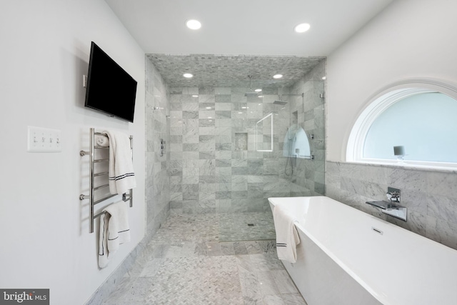 bathroom with recessed lighting, tile walls, a freestanding bath, marble finish floor, and a shower stall