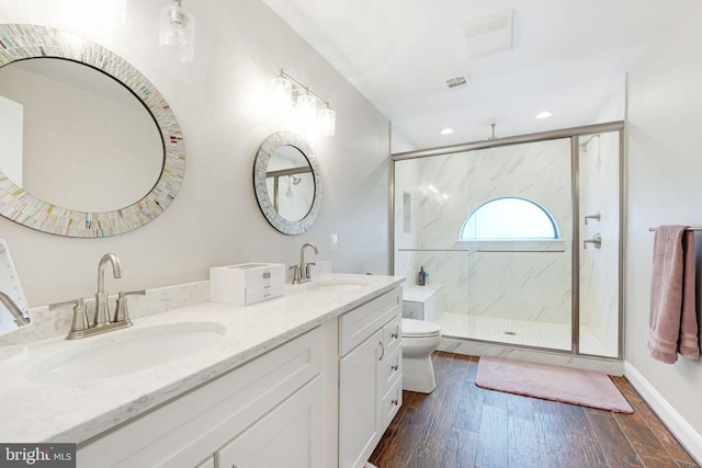 bathroom with toilet, visible vents, a sink, and wood finished floors