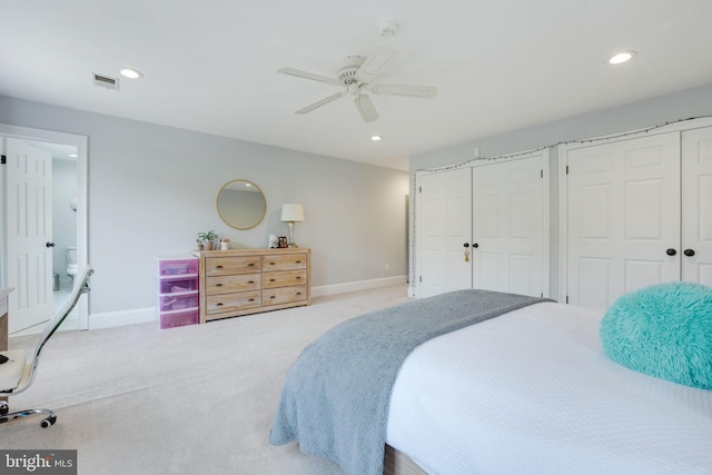 carpeted bedroom featuring baseboards, visible vents, multiple closets, and recessed lighting