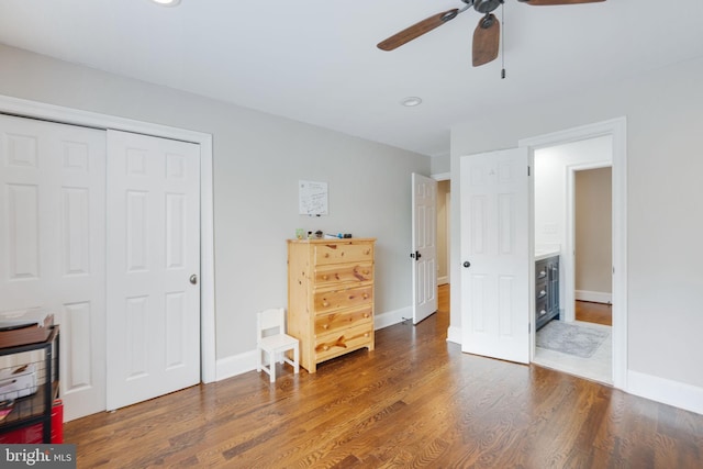 bedroom with a closet, ceiling fan, baseboards, and wood finished floors