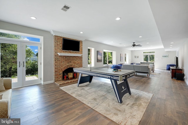 game room with recessed lighting, visible vents, french doors, a brick fireplace, and hardwood / wood-style floors