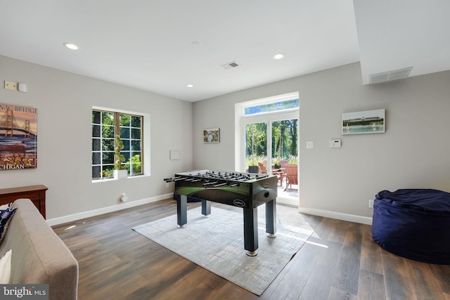 game room with dark wood-style flooring, visible vents, and baseboards