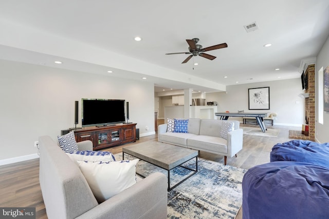 living area featuring recessed lighting, visible vents, baseboards, and wood finished floors