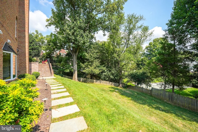 view of yard with fence and stairs