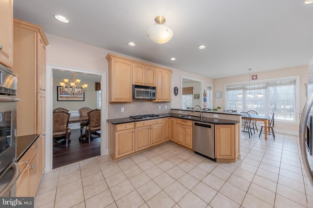 kitchen with light tile patterned floors, stainless steel appliances, light brown cabinetry, and a sink