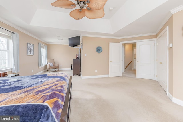 carpeted bedroom with baseboards, a tray ceiling, and crown molding