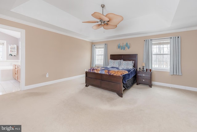 bedroom with a tray ceiling, light carpet, and baseboards