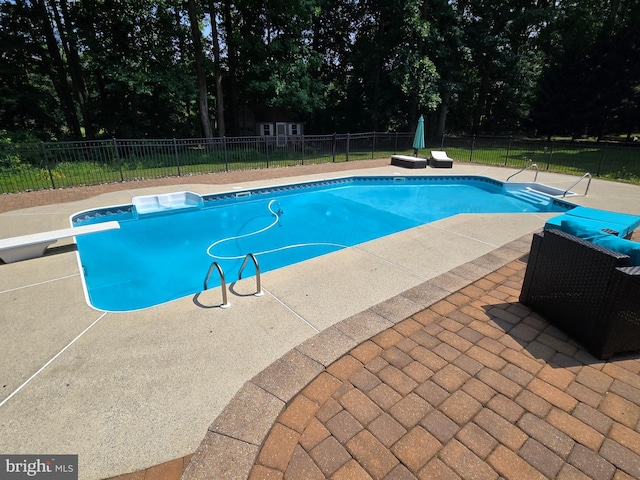 view of pool featuring a fenced in pool, a fenced backyard, a patio, and a diving board