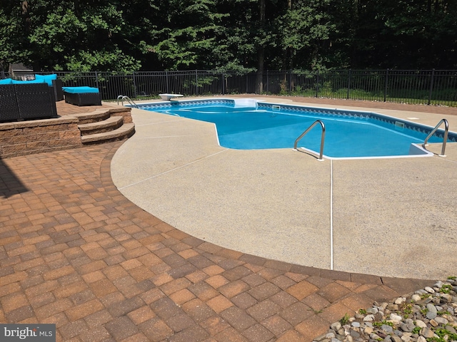 view of pool featuring a fenced in pool, a diving board, a patio, and fence