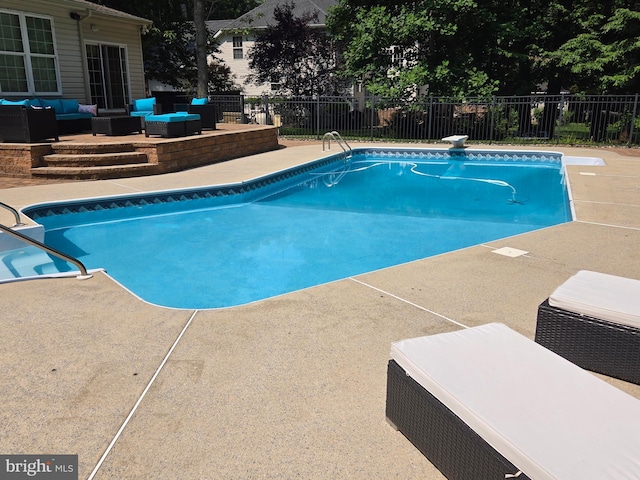 view of swimming pool with a patio, fence, an outdoor living space, and a fenced in pool