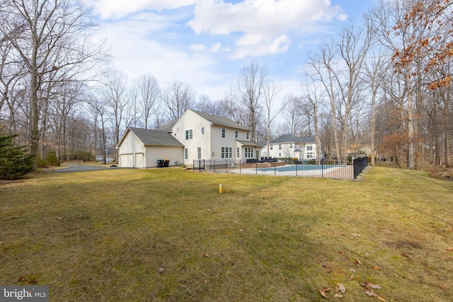 view of yard featuring a fenced in pool, fence, a detached garage, and a patio