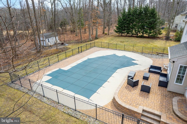 view of pool featuring a patio, a lawn, fence, and a fenced in pool