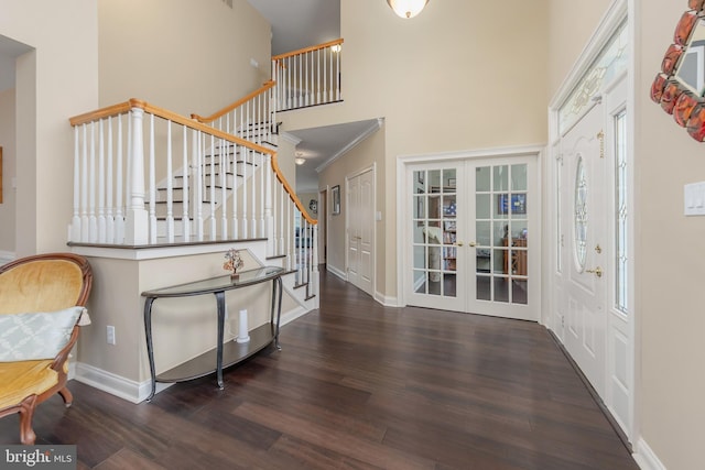 entryway with french doors, stairway, a towering ceiling, wood finished floors, and baseboards