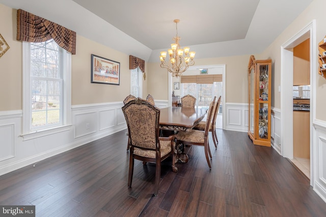 dining room featuring dark wood finished floors, a notable chandelier, and wainscoting