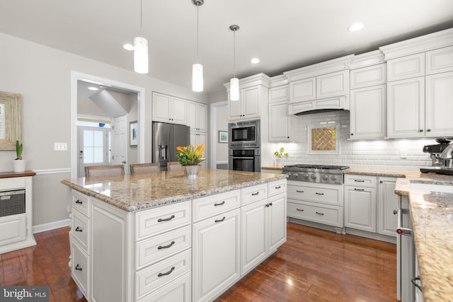 kitchen with a center island, dark wood-style flooring, backsplash, and stainless steel appliances