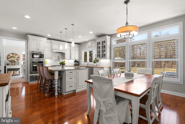 dining space featuring a wealth of natural light, recessed lighting, and dark wood-style flooring