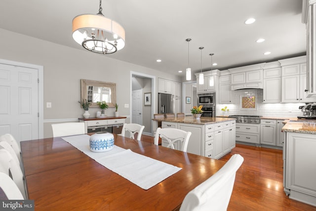 dining room with recessed lighting, wood finished floors, and a chandelier