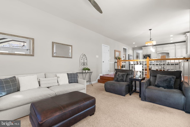 living room with recessed lighting, baseboards, and light carpet