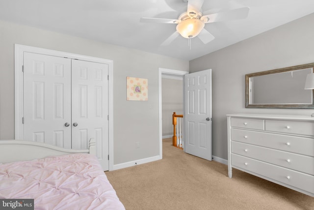 bedroom with baseboards, light carpet, a closet, and a ceiling fan