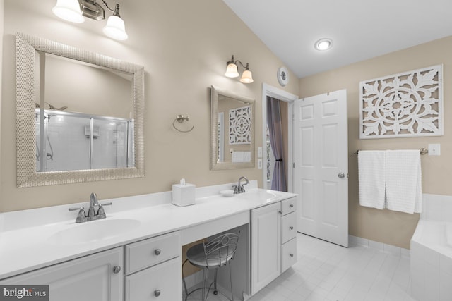 full bath with a shower stall, double vanity, tiled bath, and a sink