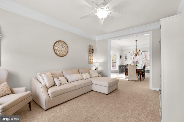 living area featuring baseboards, carpet, ornamental molding, and ceiling fan with notable chandelier