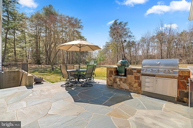 view of patio featuring grilling area, outdoor dining space, and exterior kitchen