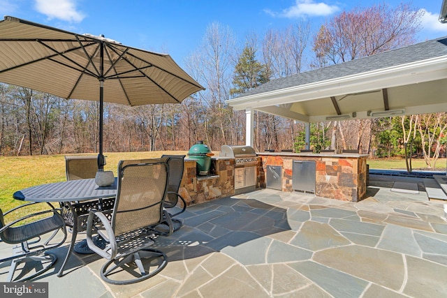 view of patio with outdoor dining space, a gazebo, area for grilling, and an outdoor kitchen