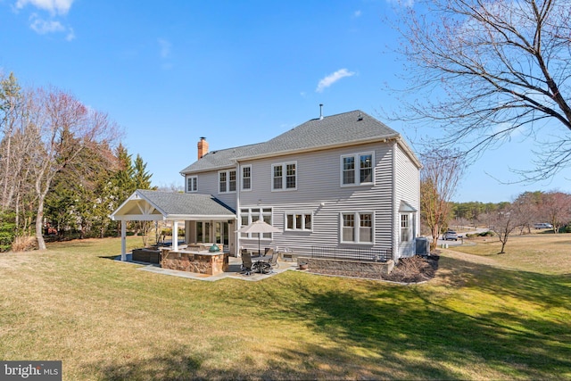 back of house with a shingled roof, central AC, a lawn, a chimney, and a patio