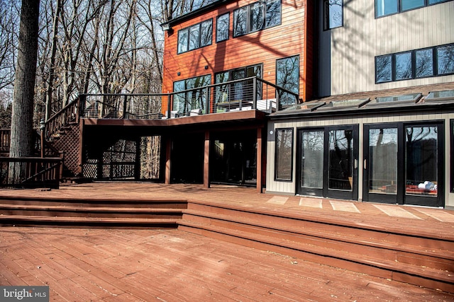 rear view of property featuring a wooden deck