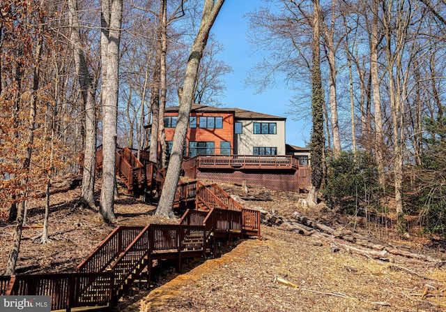 rear view of house with stairway and a wooden deck