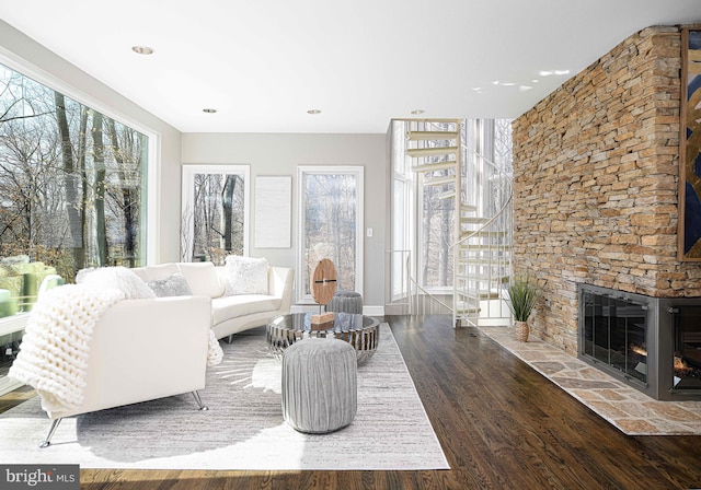 living area featuring baseboards, wood finished floors, and a fireplace