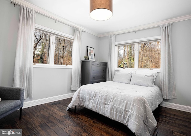 bedroom with visible vents, ornamental molding, baseboards, and hardwood / wood-style flooring