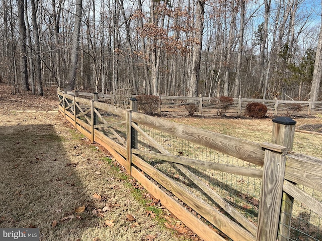 view of gate featuring fence and a wooded view