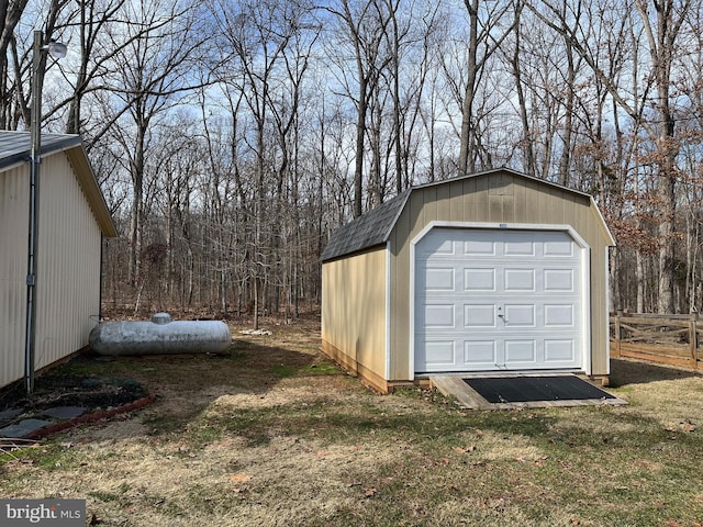 detached garage with fence and a storage unit