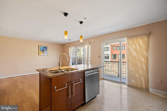 kitchen with stone counters, a sink, baseboards, dishwasher, and pendant lighting