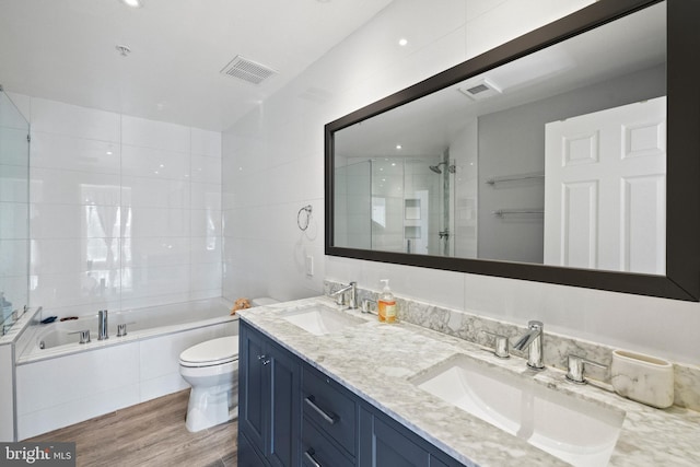 bathroom with visible vents, a sink, a tile shower, and toilet