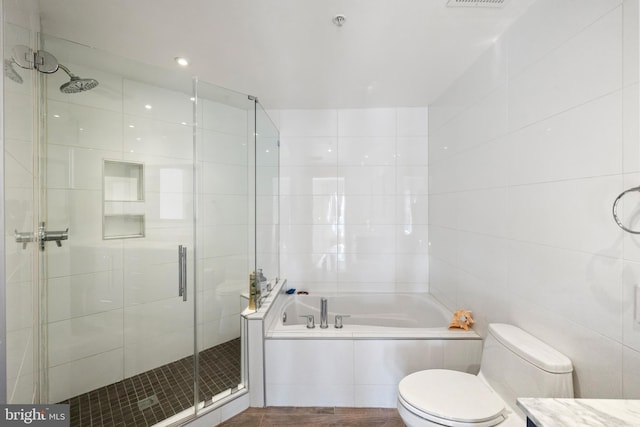 full bathroom with a garden tub, toilet, visible vents, tile walls, and a shower stall