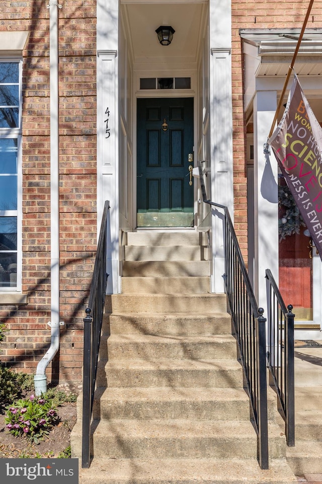 entrance to property featuring brick siding