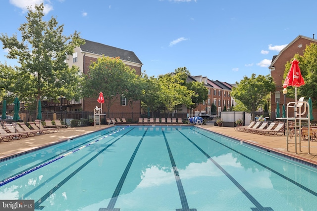 pool with a patio area and fence