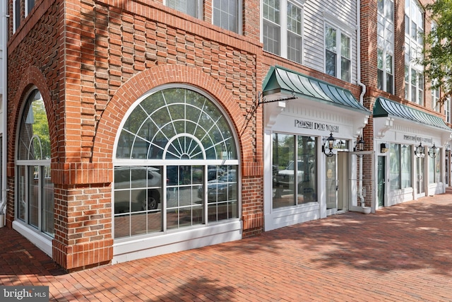 view of exterior entry featuring brick siding