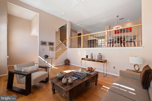 living room featuring recessed lighting, wood finished floors, visible vents, baseboards, and stairway