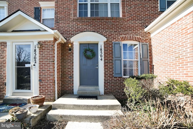 doorway to property with brick siding