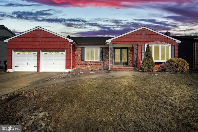 ranch-style home with a garage, a front yard, concrete driveway, and brick siding