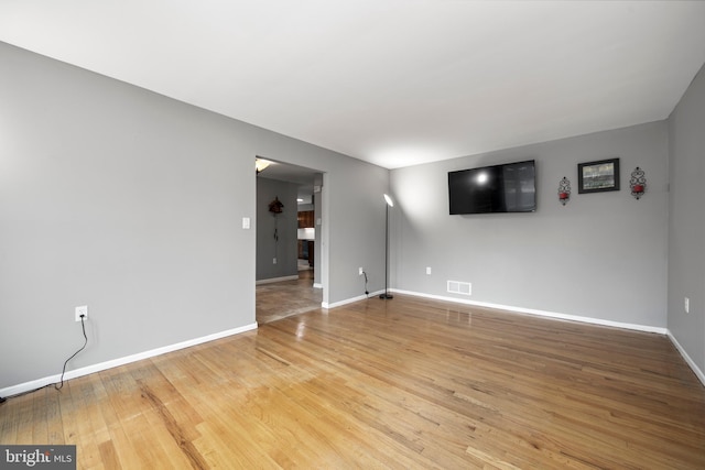 empty room with baseboards, visible vents, and light wood-style floors