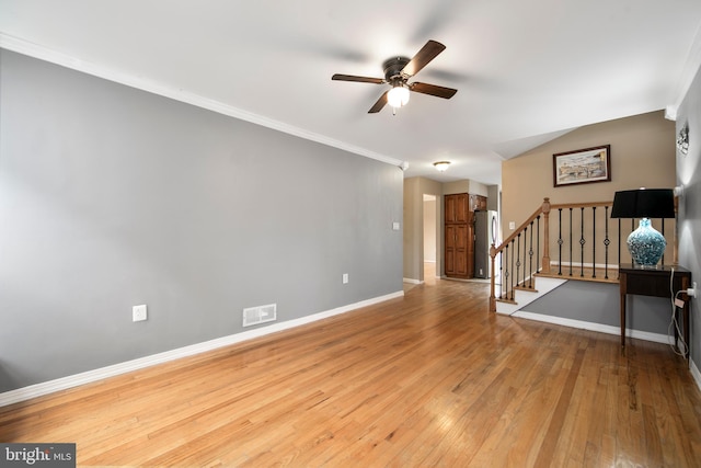 unfurnished living room featuring visible vents, ceiling fan, light wood-type flooring, baseboards, and stairs