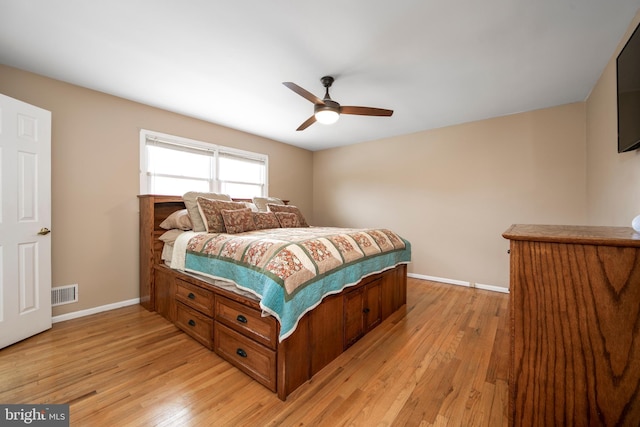 bedroom featuring baseboards, visible vents, ceiling fan, and light wood finished floors