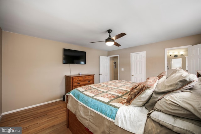 bedroom with a closet, wood finished floors, a ceiling fan, and baseboards