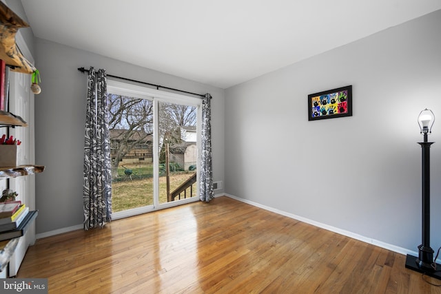 unfurnished room featuring hardwood / wood-style flooring and baseboards