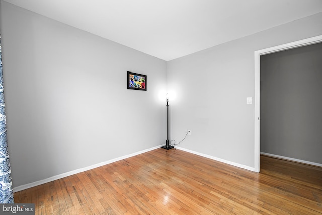 spare room with light wood-style floors and baseboards