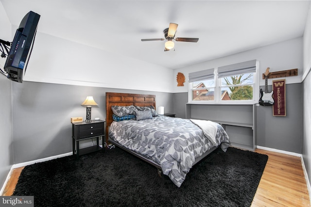 bedroom featuring ceiling fan, baseboards, and wood finished floors